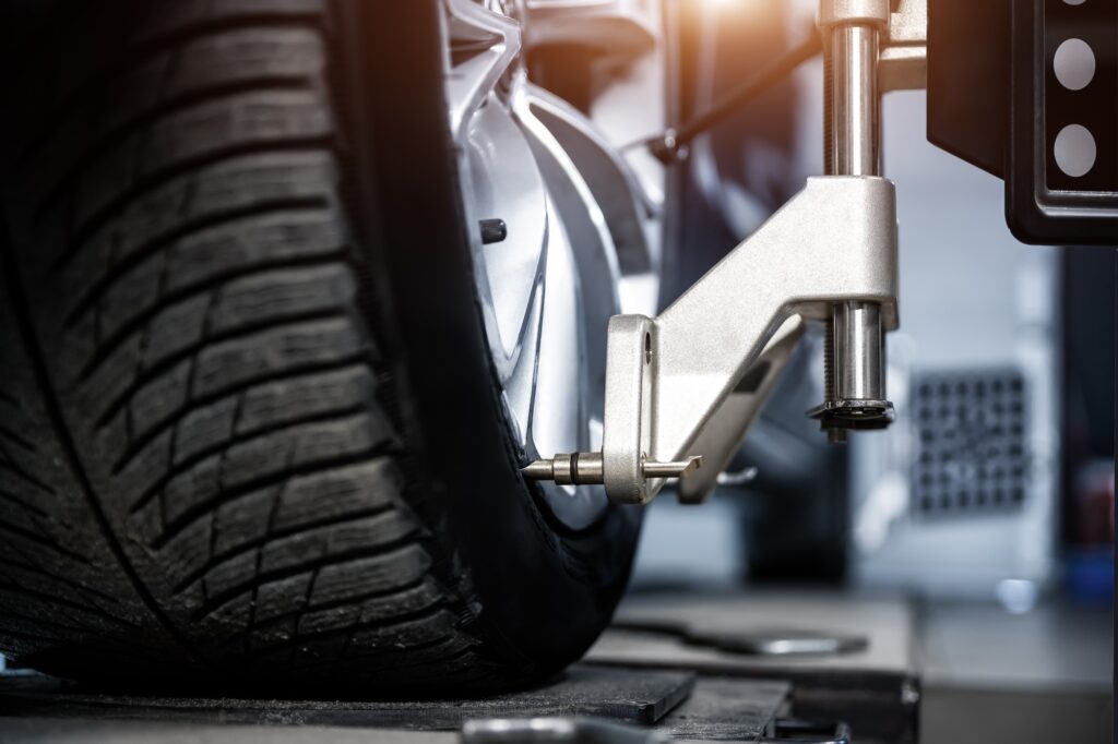 CLose-up car wheel indoors service maintenance repair center against laser sensor equipment